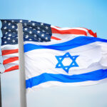 Flags of Israel and the USA against the background of the blue sky