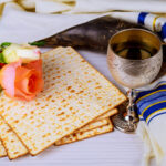 Pesah celebration concept jewish Matzoh and red sweet wine Passover holiday and spring flowers