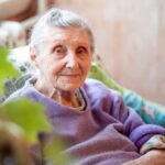 Portrait of an elderly European woman sitting at home, old grandmother resting in a chair, elderly people in quarantine at home.