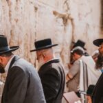 Jerusalem, Israel - November 1st, 2016: Jewsih orthodox belivers reading Torah and praying facing Western Wall, also known as Wailing Wall or Kotel in Old City in Jerusalem, Israel. It is small segment of the structure which originally composed the western retaining wall of the Second Jewish Temple atop the hill known as the Temple Mount to Jews and Christians.