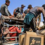 Palestinians receive humanitarian and food aid from the American Center for Humanitarian Aid (GHF), located in Rafah, southern Gaza Strip, on August 14, 2025.