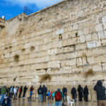 JERUSALEM, ISRAEL - December 06, 2018: A view from the Western Wall, an old and important site in Jewish history, with several men praying near it.